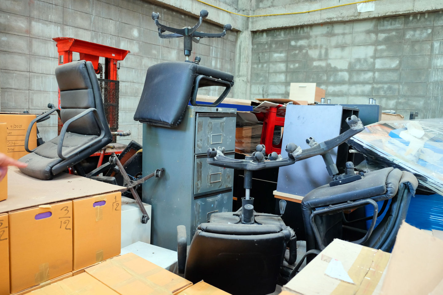Broken office chairs and wooden cabinet in the store room